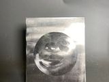 a metal plaque with a face on it on the wall