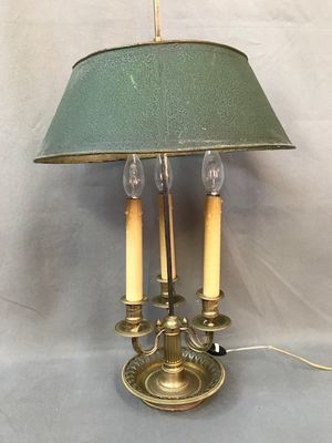 une lampe posée sur une table, munie d'un abat-jour vert
