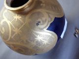 a blue and gold vase sitting on a table