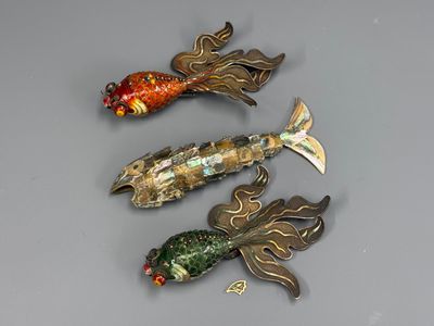 trois broches en forme de poisson posées sur une table