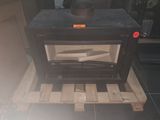 a black stove sitting on a pallet in a room