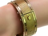 bracelet on a woman ' s arm with a gold band and a diamond