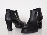 paire de bottines en cuir noir avec fermetures éclair sur fond blanc