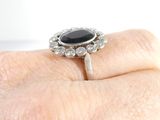 an image of a woman ' s hand holding a black and white diamond ring