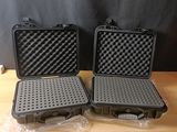 deux valises noires posées l'une à côté de l'autre sur une table en bois