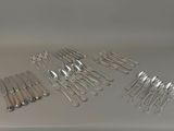 a lot of forks and spoons sitting on a table