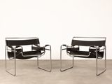 une paire de fauteuils en cuir noir dans une pièce aux murs blancs