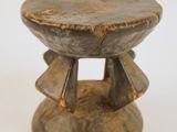 une image représentant un tabouret en bois posé sur une surface blanche