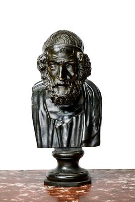 statue représentant le buste d'un homme barbu, posée sur une table en marbre