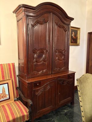une armoire en bois et une chaise dans une pièce