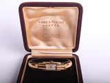 an image of a gold bracelet in a case on a white background