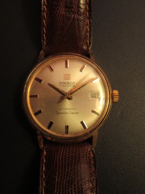 a close up of a wrist watch on a black surface