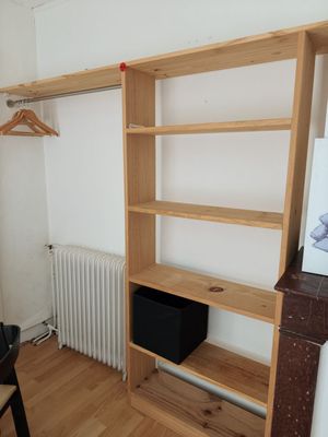 a room with a desk and a book shelf in it