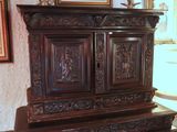 a wooden cabinet with carvings on it in a room