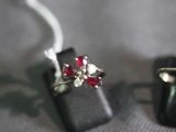 two rings with red stones on them sitting on a black box
