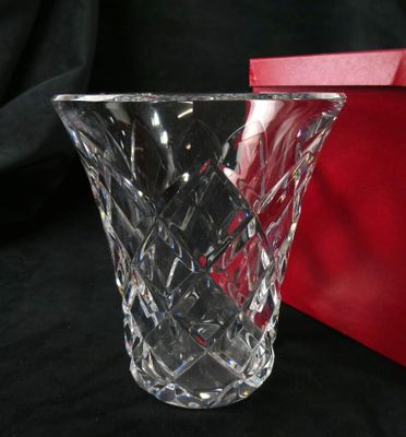 a glass vase sitting next to a red box on a table