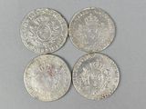 three silver coins sitting on top of a table next to each other