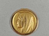 a close up of a gold coin with a woman ' s face on it