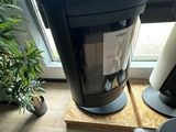 un téléviseur posé sur un meuble à côté d'une plante en pot