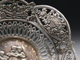 a silver plate with a picture of a woman on it