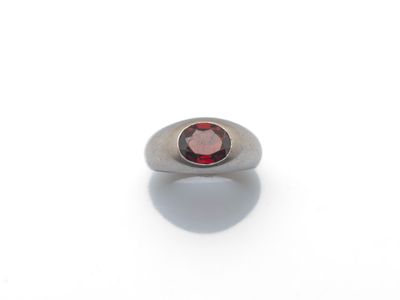 Gros plan sur une bague contenant une pierre rouge