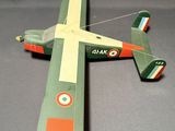 une maquette d'avion vert et orange posée sur une surface grise