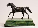 statue of a black horse on a green marble base on a white background