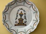 une assiette ornée d'une image représentant un vase, accrochée au mur