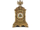 une horloge en or posée sur une surface blanche