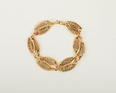 un bracelet en or orné d'un motif de feuilles
