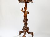 une petite table en bois sur laquelle se trouve une statue
