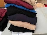 une pile de pulls posée sur une table, avec une étiquette de prix