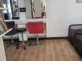 a room with a bed, desk, chair, and mirror