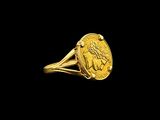 Gros plan sur une bague en or ornée d'une pièce de monnaie