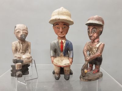 trois figurines posées sur une table en verre