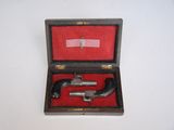 an old gun in a wooden case sitting on a white surface