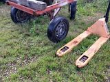 a small wooden cart and a fork on the grass
