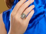 an image of a woman in a blue dress with a ring on her finger