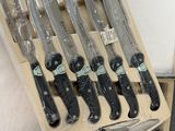 a lot of knives that are in a wooden box