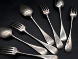 six forks and spoons are arranged in a circle on a black surface