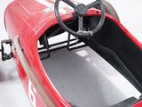 a red pedal car with a steering and a steering wheel