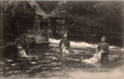 Dans un village, plusieurs personnes traversent une rivière à gué.