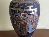 un vase avec un tableau posé sur une table