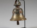 an old bell on a stand with a bird on it