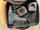 un sac noir posé par terre, contenant des outils