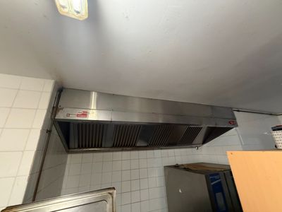 vue d'une cuisine équipée d'une cuisinière et d'une hotte aspirante