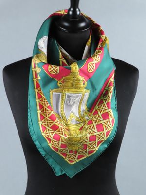 une écharpe verte et rouge ornée d'un motif doré et rouge