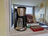 une cafetière posée sur un plan de travail près d'une fenêtre