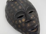 une image représentant un masque noir parsemé de points dorés
