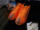 a pair of orange and black shoes on a bed